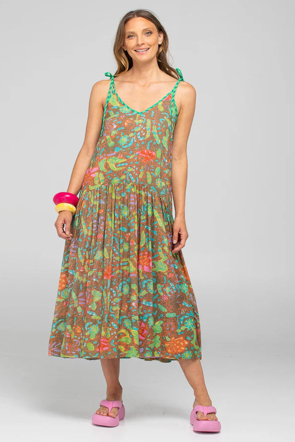 Woman wearing a colorful floral dress on a gray background