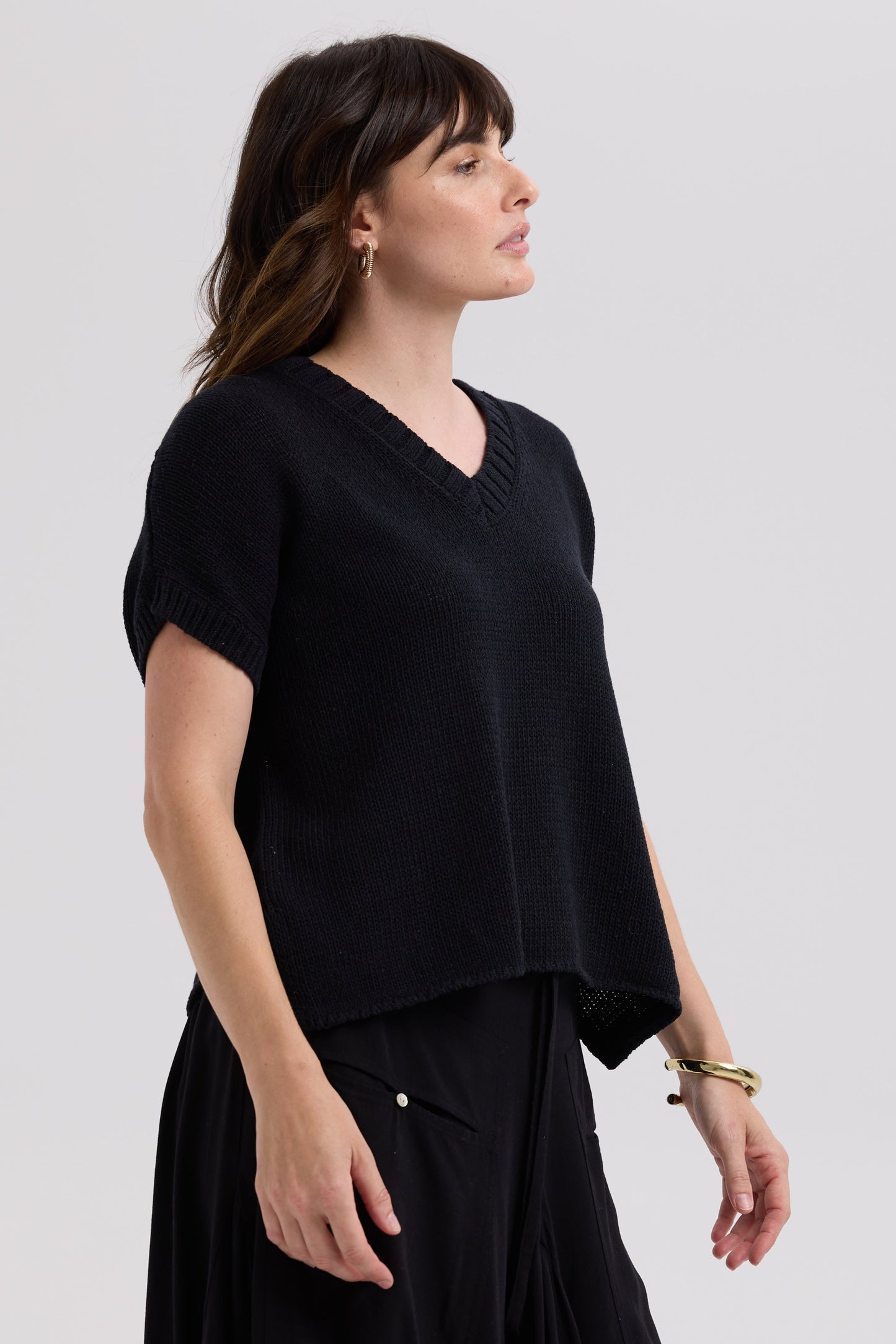 Woman wearing a black top and skirt on a white background