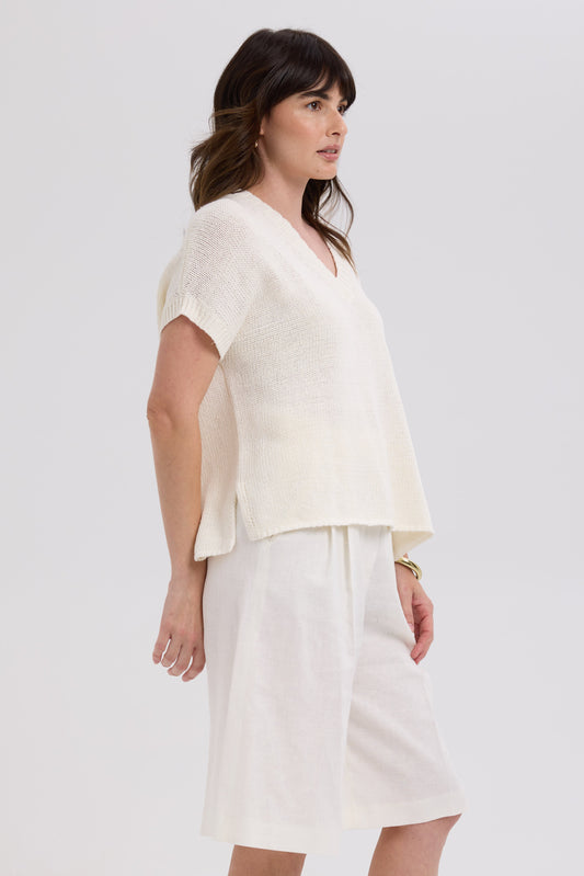 Woman wearing a white outfit on a plain background