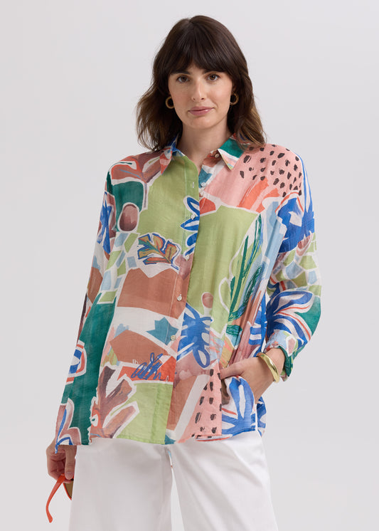 Woman wearing a colorful patterned shirt against a white background