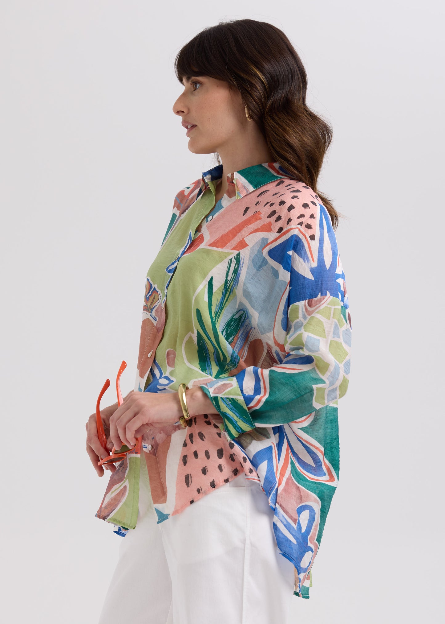 Woman wearing a colorful patterned shirt on a white background