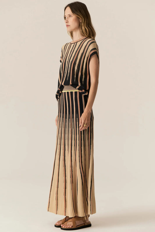 Woman wearing a black and beige striped dress on a plain background