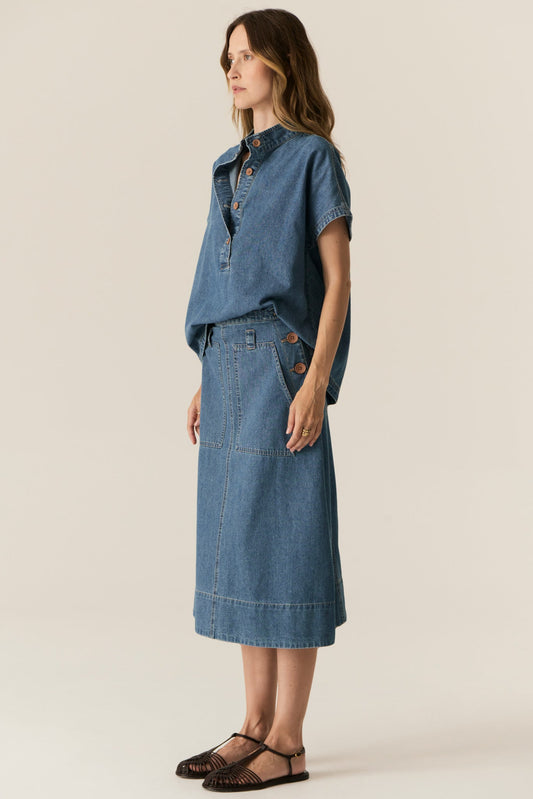 Woman wearing a denim outfit on a beige background