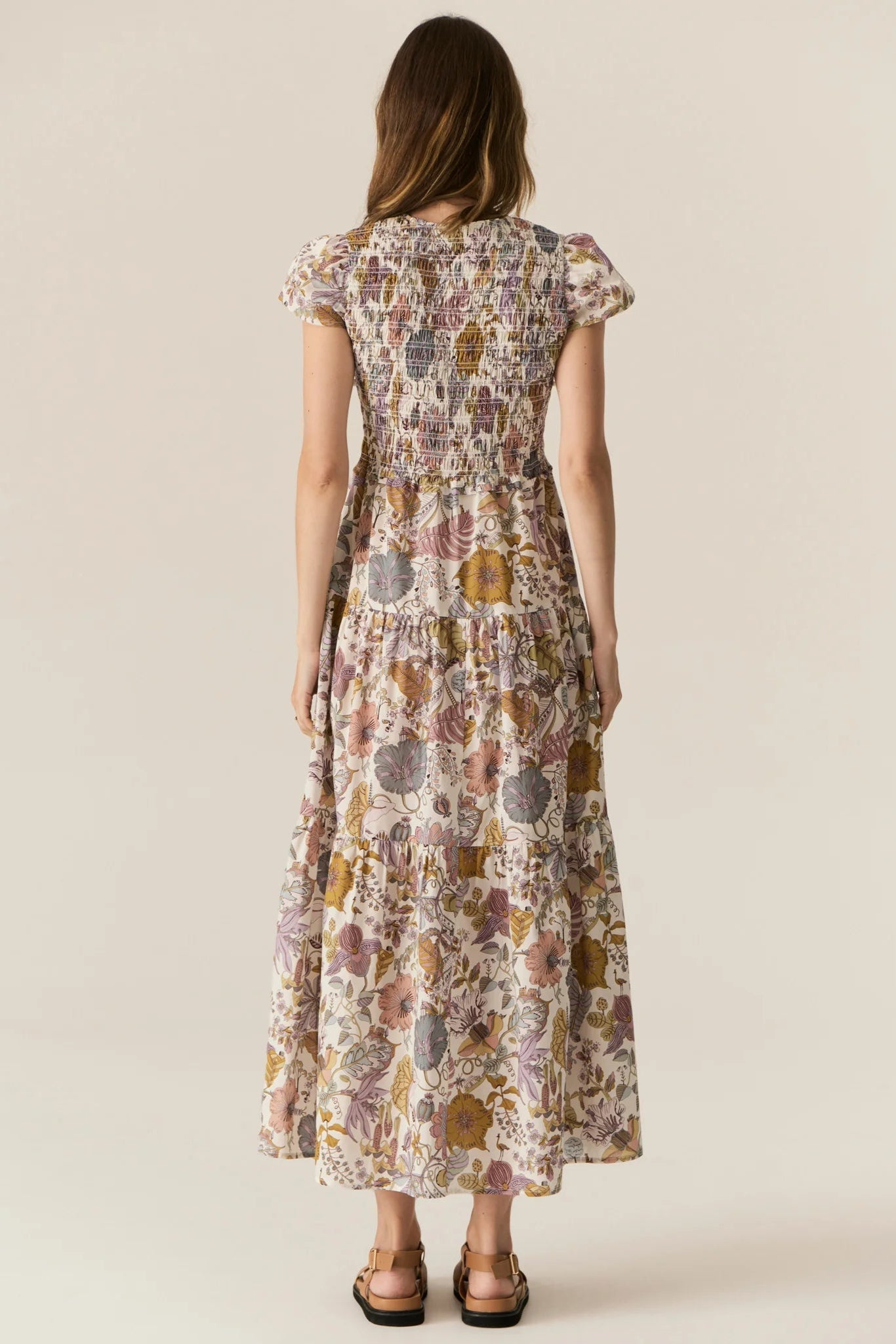 Woman wearing a floral dress on a beige background