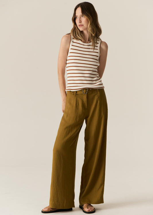 Woman wearing a striped tank top and wide-leg pants on a plain background
