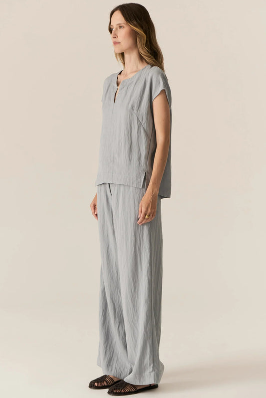 Woman wearing a gray outfit on a beige background