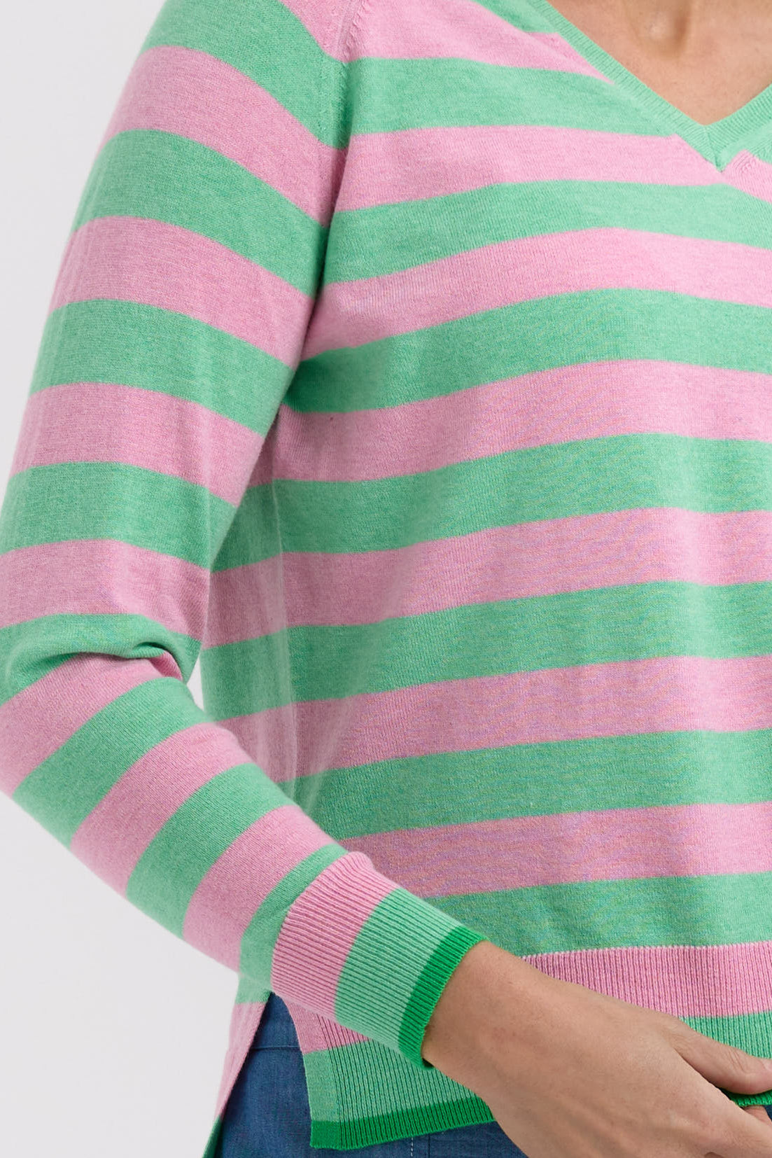 Close-up of a green and pink striped sweater on a white background