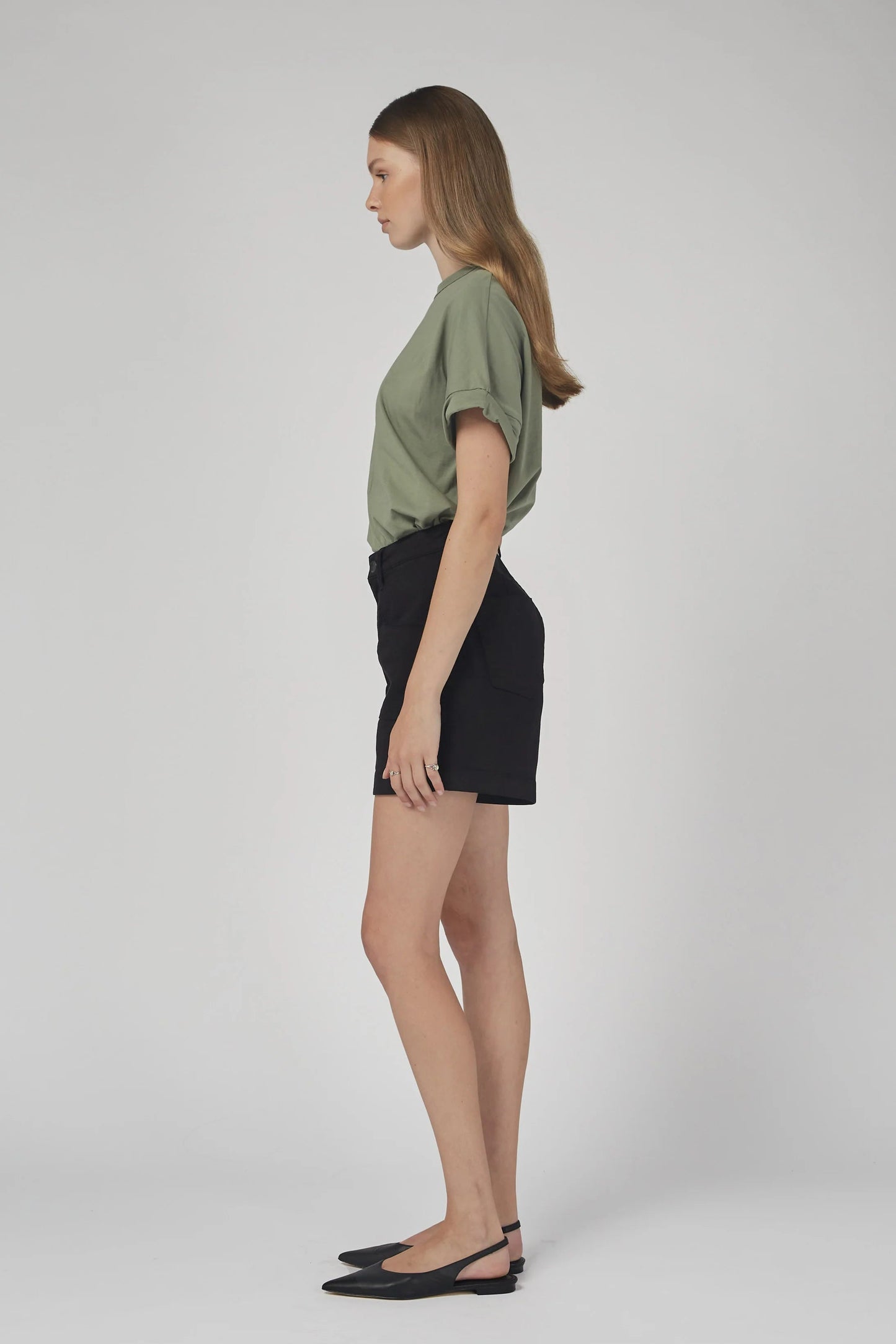 Woman wearing a green top and black skirt on a white background