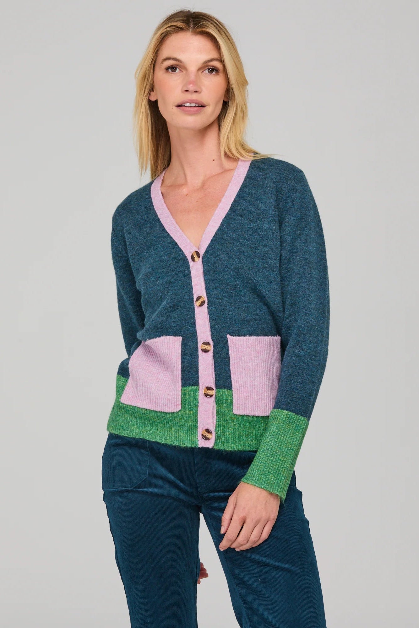 Woman wearing a colorful cardigan with a plain background