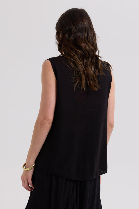 Woman wearing a black sleeveless top and skirt on a white background