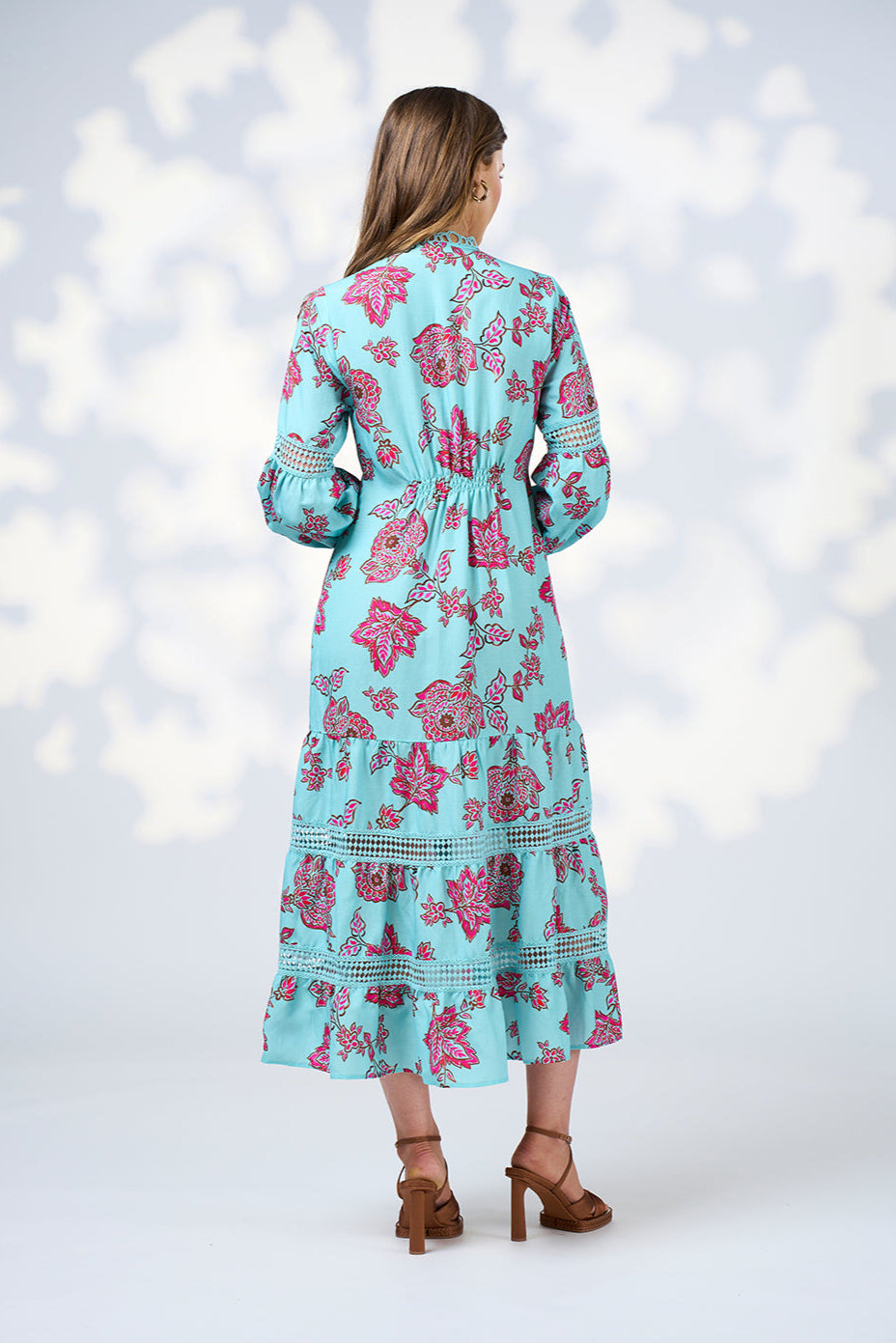 Woman wearing a blue floral dress with a white background