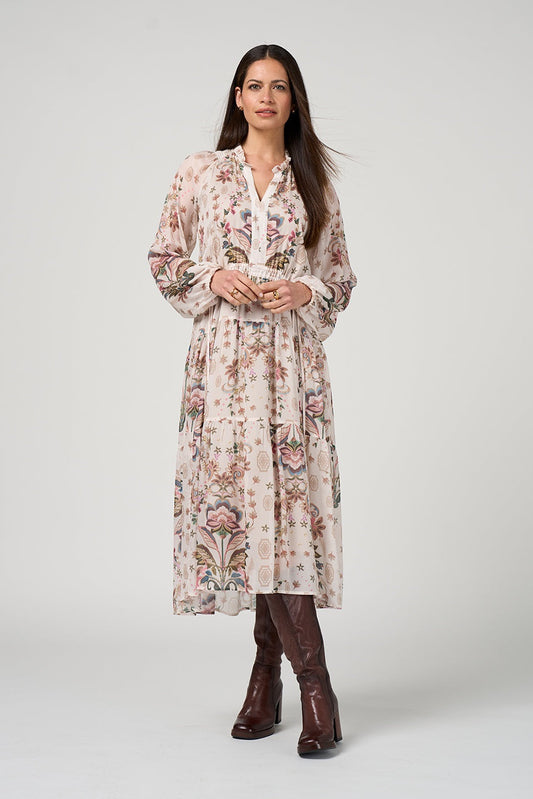 Woman wearing a floral dress with brown boots on a white background