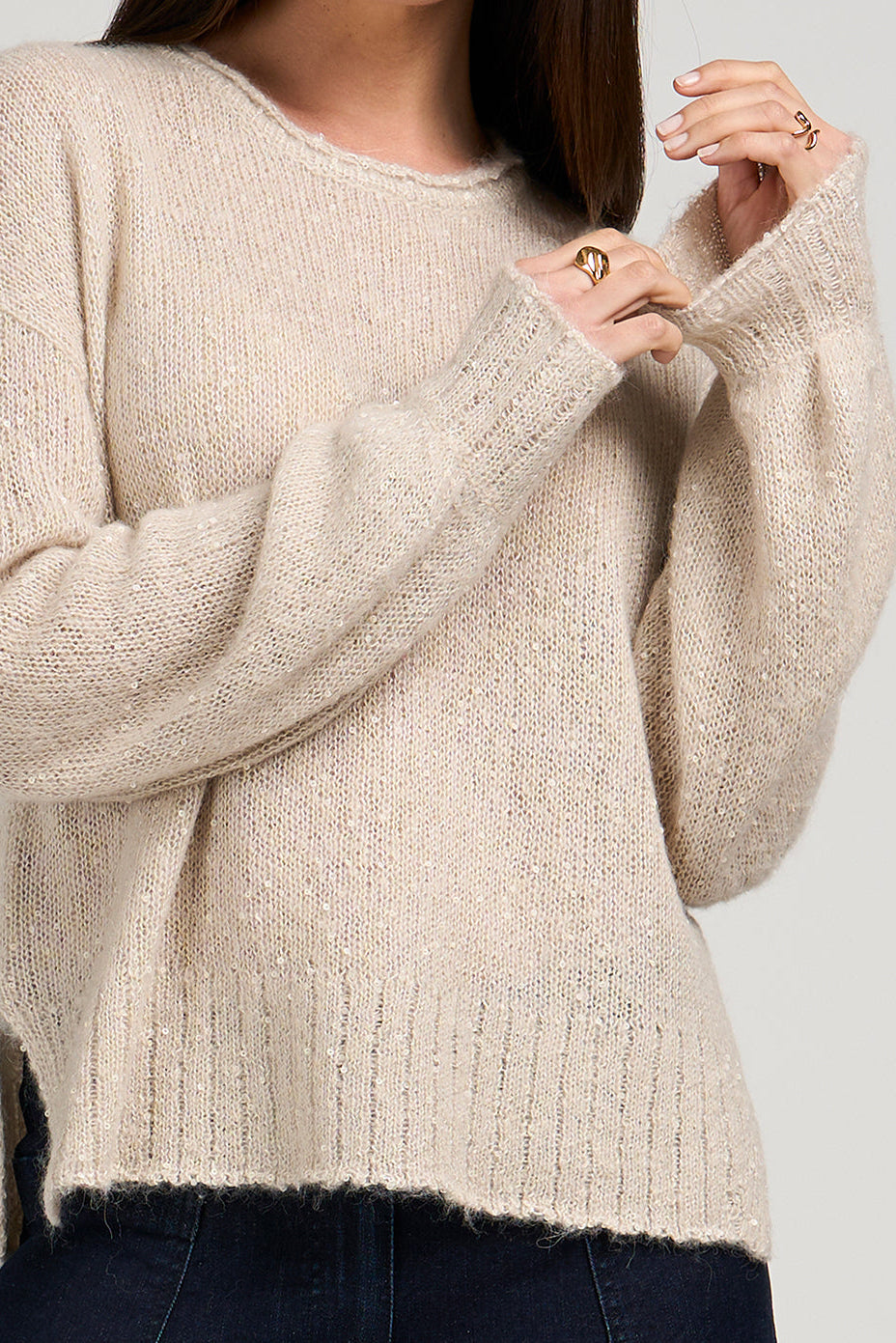 Beige sweater worn by a person on a plain background