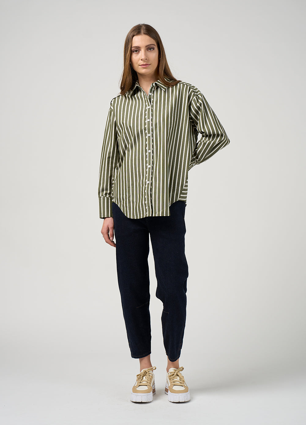 Woman wearing a striped shirt and dark pants on a white background