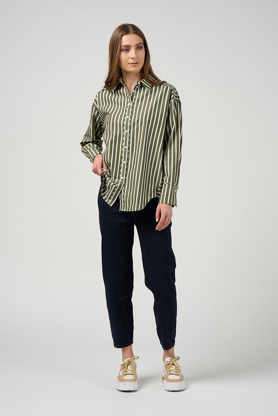 Woman wearing a striped shirt and black pants on a white background