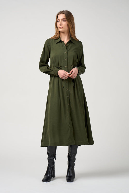 Woman wearing a green dress with long sleeves on a white background