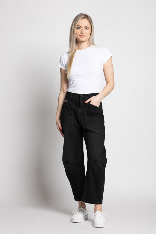 Woman wearing a white t-shirt and black pants on a plain background