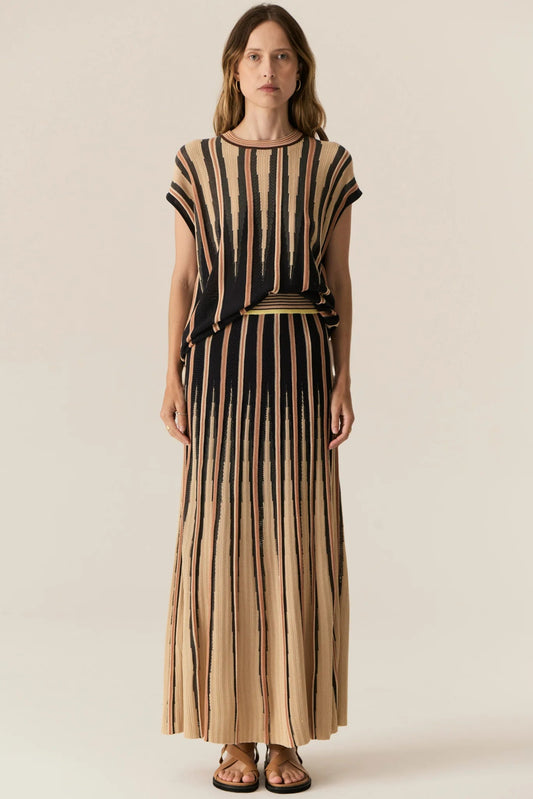 Woman wearing a black and beige striped dress on a plain background