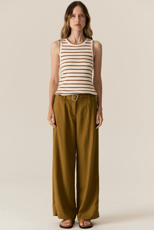 Woman wearing a striped sleeveless top and wide-leg pants on a beige background