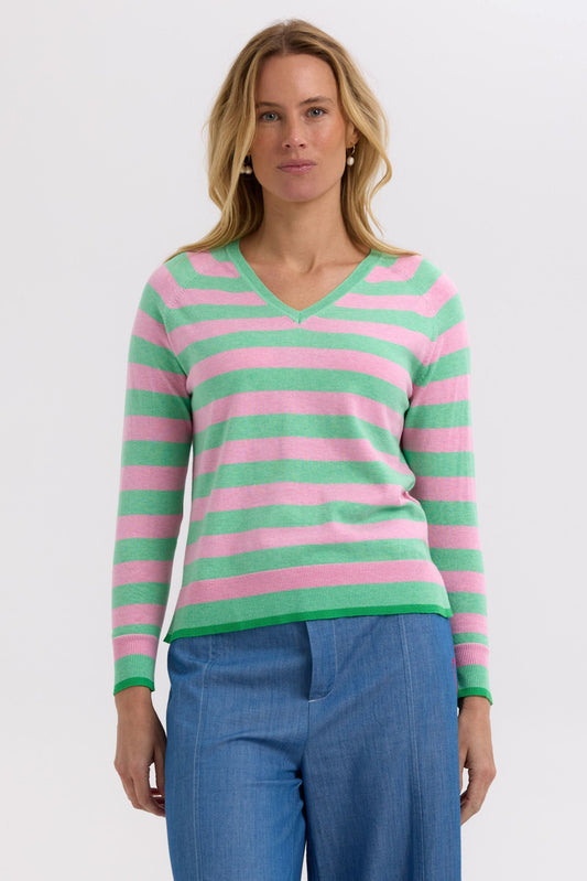 Woman wearing a pink and green striped sweater on a white background