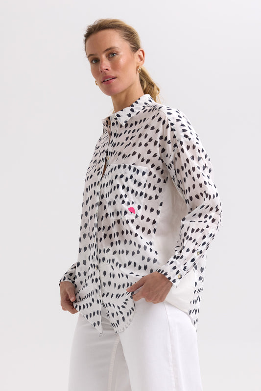 Woman wearing a white blouse with black polka dot pattern on a white background