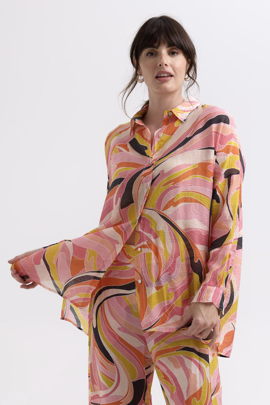 Woman wearing a colorful patterned outfit on a white background