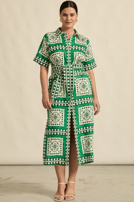 Woman wearing a green and white patterned dress against a beige background